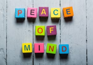 Mind. Peace of Mind wooden sign with a beach on background