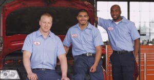 Filling Your Bench with Chris Cotton of AutoFix Auto Shop Coaching; 3 young mechanics with uniforms pose in front of a red car with open hood