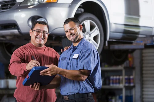 Scorecard for Success | Chris Cotton of AutoFix Auto Shop Coaching. Image of a n auto shop owner and mechanic looking the performance indicators in a tablet.