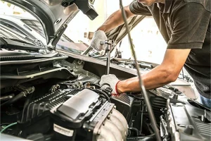 The Secret to Solving the Auto Tech Shortage | AutoFix Auto Shop Coaching. Close-up image of an auto mechanic using wrench to repair a car engine in auto car garage.