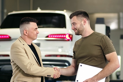 Expert Auto Repair Coaching - Client Retention Strategies | AutoFix. Mechanic shaking hands with happy male client after getting auto repairs.