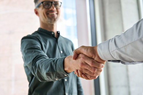 Achieve Auto Shop Excellence with AutoFix Auto Shop Coaching with Real Business Transformation Stories. Image of a happy diverse auto repair shop owner shaking hands with a male auto repair shop coach.