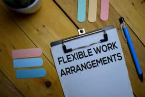 Coaching on flexible work arrangements from AutoFix Auto Repair Shop Coaching. Image of paperwork with "Flexible Work Arrangements" written on it, isolated on a wooden background.