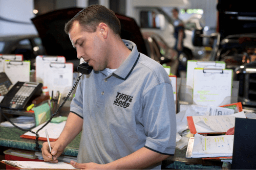 AutoFix Auto Shop Coaching image of a man talking on the phone while taking note