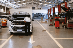 professional business coaching, AutoFix Auto Shop Coaching. Image of a professional technician inspecting a vehicle in a spacious, well-equipped auto repair facility.