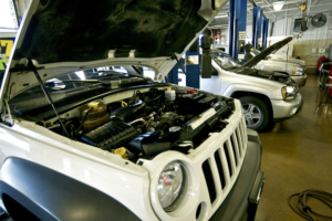 Auto repair shop coaching in 2025 by AutoFix. Image of open vehicle hoods and hydraulic lifts inside a bright, organized repair shop.