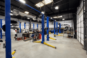 Autofix blueprint, Auto repair shop coaching by AutoFix Auto Shop Coaching. Image of a spacious, modern repair facility with multiple vehicle lifts and cars being serviced.