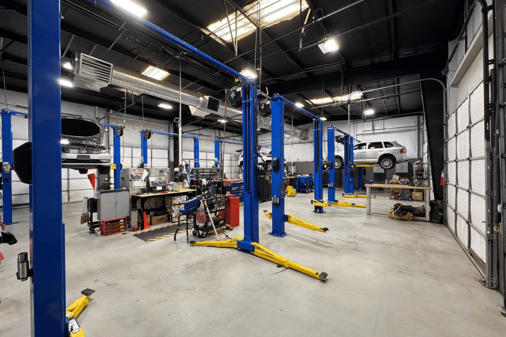 Autofix blueprint, Auto repair shop coaching by AutoFix Auto Shop Coaching. Image of a spacious, modern repair facility with multiple vehicle lifts and cars being serviced.