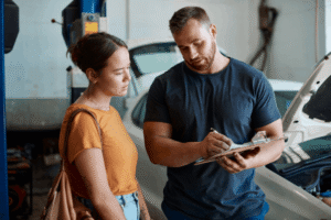 Automotive service writer duties, auto shop coaching by AutoFix Auto Shop Coaching. Image of automotive service writer reviewing service details with a customer, highlighting transparent communication, accurate diagnostics, and a customer-first approach to vehicle care.